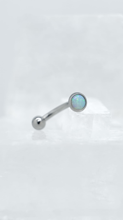 Kolczyk do rook z białym opalem – tytan implant-grade | detal Zbliżenie na detal kolczyka do piercingu rook. Gładkie wykończenie tytanu i precyzyjne osadzenie białego opalu zapewniają komfort noszenia i estetykę.